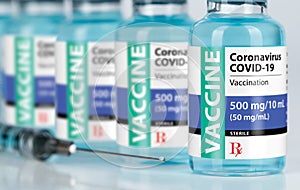 Coronavirus COVID-19 Vaccine Vials and Syringe On Reflective Surface photo