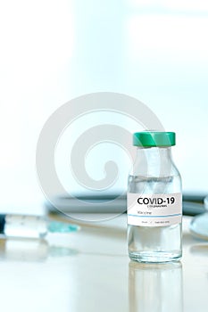 Coronavirus COVID-19 Vaccine Vials and Syringe On Reflective Surface