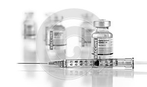 Coronavirus COVID-19 Vaccine Vials and Syringe On Reflective Surface