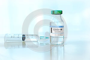 Coronavirus COVID-19 Vaccine Vials and Syringe On Reflective Surface