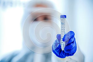 Coronavirus epidemic in the world, a nurse in a respiratory mask holds a test tube with sample