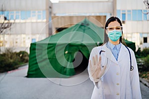 Coronavirus ER doctor in front of isolation hospital.Covid-19 physician with protective glasses / mask performing triage for virus