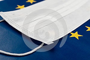 Coronavirus in Europe. Medical antibacterial mask on the background of the flag of the European Union