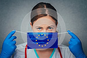 Coronavirus in European Union, Female Doctor Portrait hold protect Face surgical medical mask with Europa Union Flag. Illness,