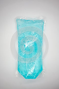 Coronavirus hand sanitizer gel to wash hands for flu virus prevention. Blue gel in clear plastic bag on white