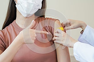 Coronavirus hand of young woman nurse,doctor giving syringe vaccine, inject shot to asian arm's patient. Vaccination,