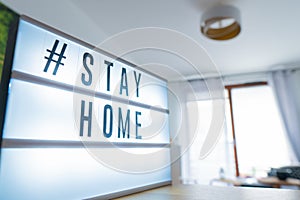 Coronavirus home sign lightbox with text hashtag Stayhome glowing in light. COVID-19 banner to promote self isolation staying at