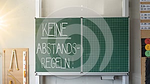 CORONAVIRUS - Hygieneplan an Schulen: Klassenzimmer mit grÃÂ¼ner Schultafel und der Aufschrift: KEINE ABSTANDSREGELN photo