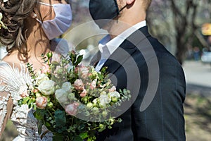 Coronavirus infection 2020. Kovid 19. Portrait of a masked bride and groom during a wedding ceremony. Oudoor. Weddings during the