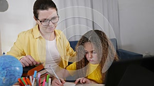 coronavirus. learning home a mom daughter. School kid. Home school. mom helps daughter do pandemic homework for school