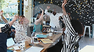 Coronavirus lockdown ending. Happy multiethnic business team taking masks off, celebrate victory with confetti at office