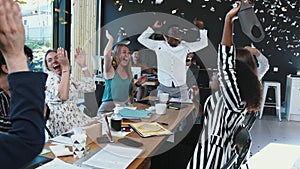 Coronavirus lockdown ending. Happy multiethnic business team taking masks off, celebrate victory with confetti at office