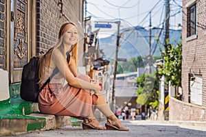 Coronavirus is over. Quarantine weakened. Take off the mask. Now you can travel. Young woman tourist in Bukchon Hanok