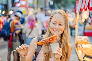 Coronavirus is over. Quarantine weakened. Take off the mask. Now you can travel. Young woman tourist eating Typical