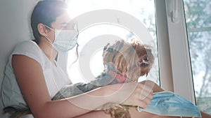 Coronavirus pandemic concept. little teenage girl puts a medical mask on a dog lifestyle. self-isolation concept virus
