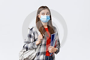 Coronavirus pandemic, covid-19 education, and back to school concept. Smart female student, freshman girl heading to