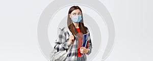 Coronavirus pandemic, covid-19 education, and back to school concept. Smart female student, freshman girl heading to