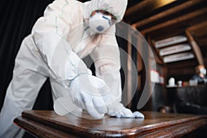 Coronavirus Pandemic. A disinfector in a protective suit and mask sprays disinfectants in the house or office