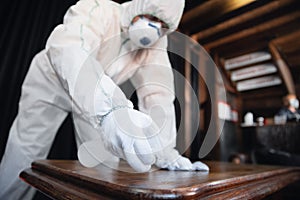 Coronavirus Pandemic. A disinfector in a protective suit and mask sprays disinfectants in the house or office photo