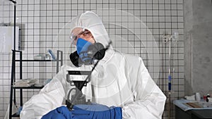Coronavirus pandemic - Doctor in protective suit disinfecting himself in a hospital chamber.