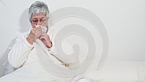 Coronavirus pandemic. Healthcare, flu, hygiene and people concept. Sick senior woman with paper wipe blowing his nose at