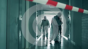 Coronavirus pandemic, virus prevention, COVID-19 concept. Disinfection experts are decontaminating a corridor