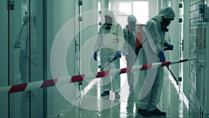 Coronavirus pandemic, virus prevention, COVID-19 concept. Hall is getting decontaminated by workers in hazmat suits