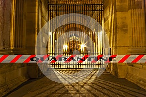 Coronavirus in Paris, France. Quarantine sign. Concept of COVID pandemic and travel in Europe. The Louvre Palace by night