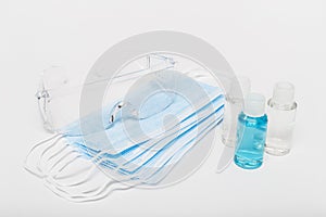 Coronavirus personal protective equipment. Protective glasses, masks and alcohol sanitizing gel in small bottles on the