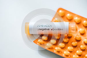 Coronavirus positive test sample and pills on a white backgorund. Coronavirus / healthcare concept.