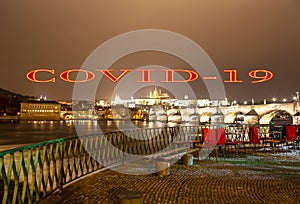 Coronavirus in Prague, Czech Republic. Embankment of the Vltava River near Charles Bridge, night. Covid-19 sign.