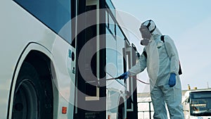 Coronavirus prevention, epidemic concept. Bus entrance is getting chemically decontaminated