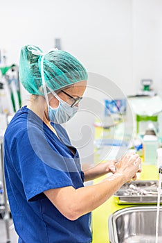 Coronavirus prevention. Nurse washing her hands after treat a patient with Covid-19 infection. Medical sanitizing photo