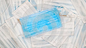 Coronavirus protection. Many antiviral protective medical face masks with ear loops spread out on a blue background. Surgical mask