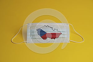 Coronavirus protective mask. Medical mask with Czech Republic flag and maps combined. Yellow background. Face mask protection