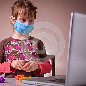 Coronavirus quarantine: game and occupation for child at home during quarantine of coronavirus. Young girl with protect medical