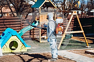 Coronavirus quarantine. man wearing protective hazmat suit spraying disinfectant and chemicals.