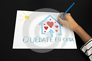 Coronavirus quarantine in Spain. Kid hand draw picture with spanish words Quedate en casa - Stay at home photo