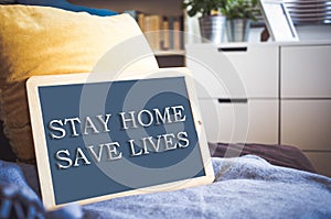 coronavirus quote stay home, save lives grey board sign with message of self isolation for social responsability on home