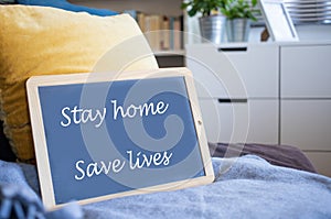 coronavirus quote stay home, save lives grey board sign with message of self isolation for social responsability on home