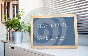 coronavirus quote stay home, save lives grey board sign with message of self isolation for social responsability on home