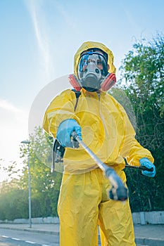 Coronavirus. A sanitation worker wearing a mask and cleaning the streets. Sterilize urban decontaminate city. Disinfecting against photo