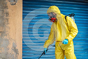 Coronavirus. A sanitation worker wearing a mask and cleaning the streets. Sterilize urban decontaminate city. Disinfecting against