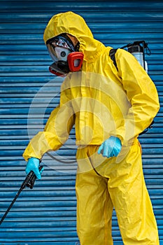 Coronavirus. A sanitation worker wearing a mask and cleaning the streets. Sterilize urban decontaminate city. Disinfecting against