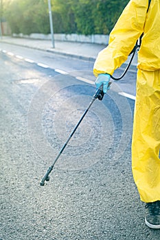 Coronavirus. A sanitation worker wearing a mask and cleaning the streets. Sterilize urban decontaminate city. Disinfecting against