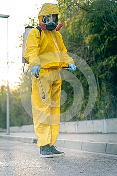 Coronavirus. A sanitation worker wearing a mask and cleaning the streets. Sterilize urban decontaminate city. Disinfecting against