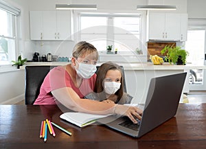 Coronavirus school closures and lockdown. Mum and bored daughter with masks studying online at home