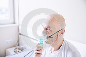 Coronavirus sick man breathing with oxygen mask. Patient in hospital.