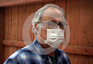 Coronavirus. Sick man with corona virus wearing mask protection recovering from the illness in home. Quarantine. Patient isolated