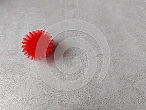 Coronavirus symbol on white textured table, rubber bowl with red spikes in the shape of a coronavirus virus photo